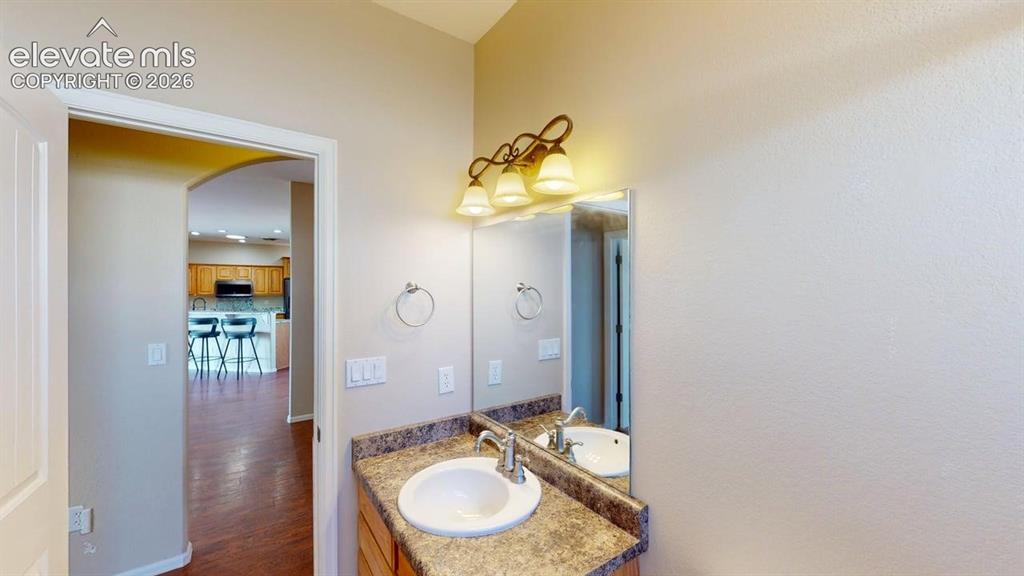 Image 21 of 50: Vanity featuring a single basin sink, decorative wall-mounted light fixture