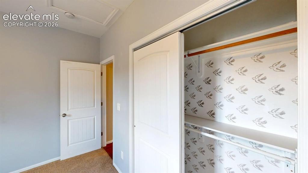 Image 28 of 50: Sliding closet doors with interior shelving and a hanging rod