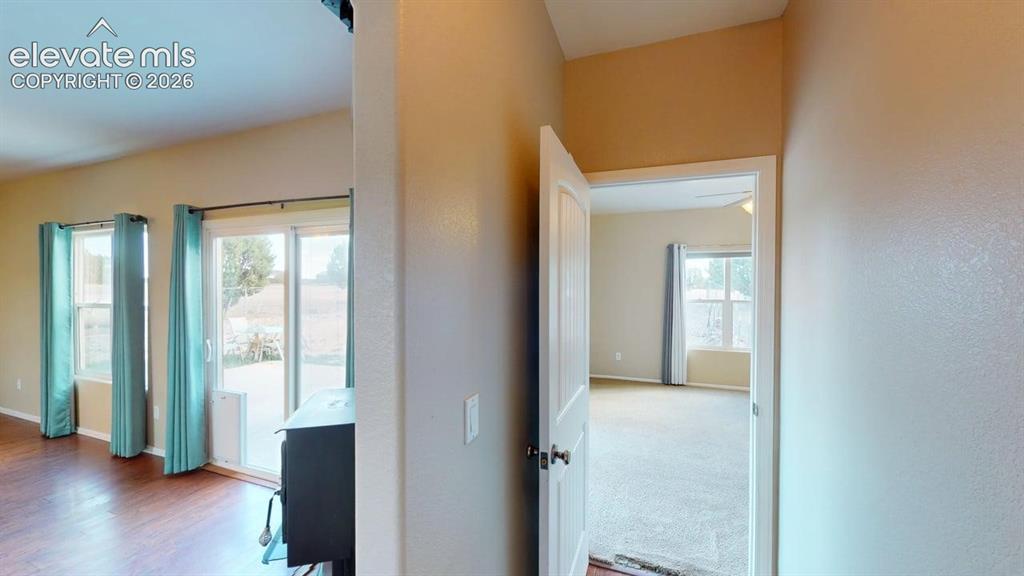 Image 29 of 50: Wood-finish flooring, sliding glass door, built-in fireplace, and vaulted c
