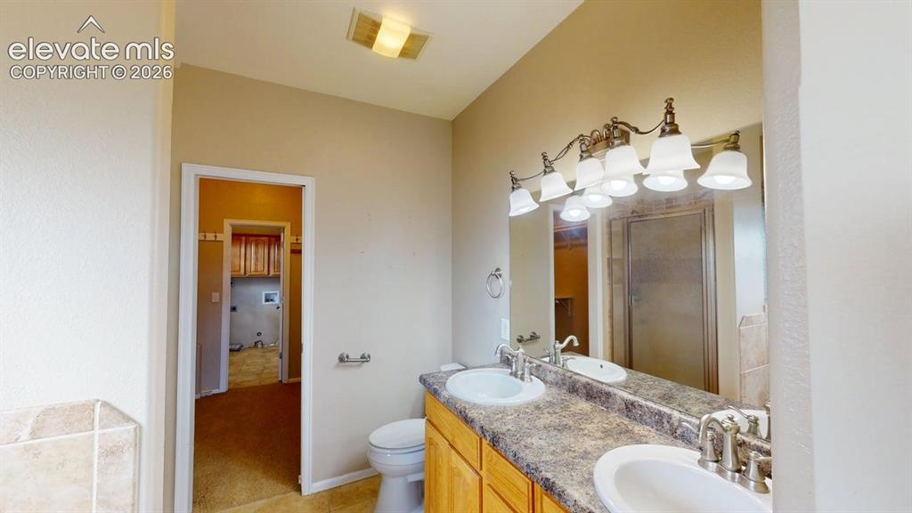 Image 34 of 50: Dual vanity with integrated sinks, brushed nickel fixtures, and a multi-bul