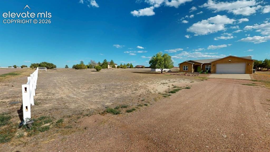Image 45 of 50: Ranch-style residence featuring an attached garage, white fencing, and a gr