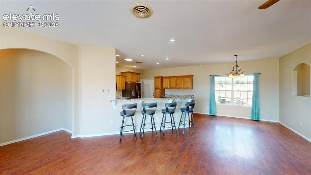 Image 6 of 50: Wood-finish flooring throughout, arched wall opening, recessed lighting, an