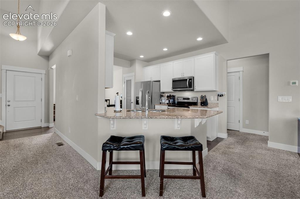 Image 11 of 40: Counter bar extends into back of  living room