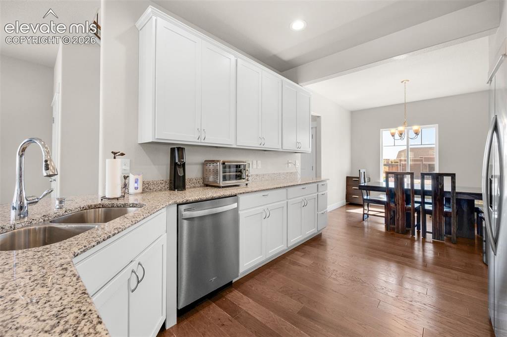 Image 14 of 40: Engineered plank flooring in kitchen and dining area