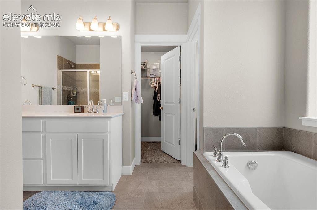 Image 22 of 40: Lots of space in primary bath. Walk-in closet is at far end