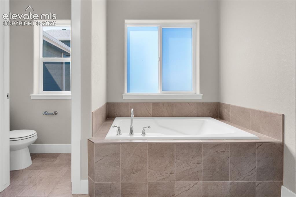 Image 24 of 40: Even a soaking tub in primary bedroom
