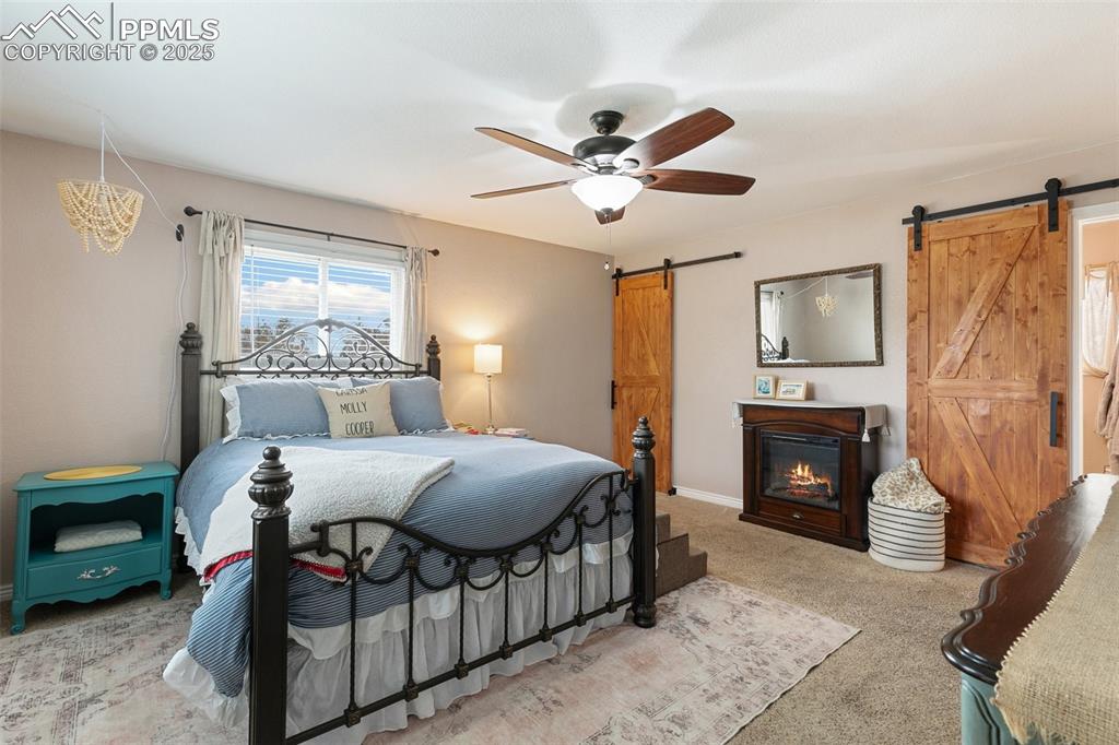 Image 14 of 29: Upstairs is your primary suite, complete with barn doors at the closet and 