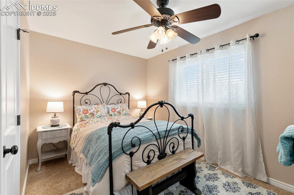 Image 18 of 29: This main level Bedroom features carpet and a ceiling fan.