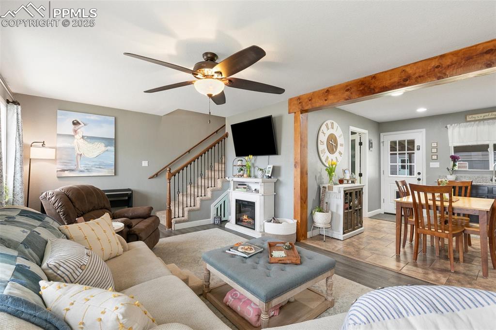 Image 4 of 29: The Living Room is a cozy oasis with ceiling fan and is open to the Kitchen