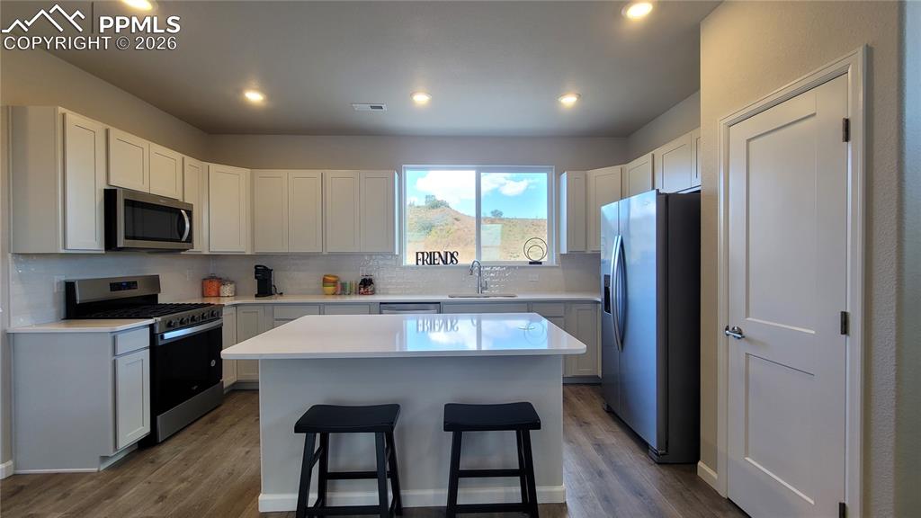 Image 13 of 28: Kitchen with Quartz countertop, pantry, island providing additional seating
