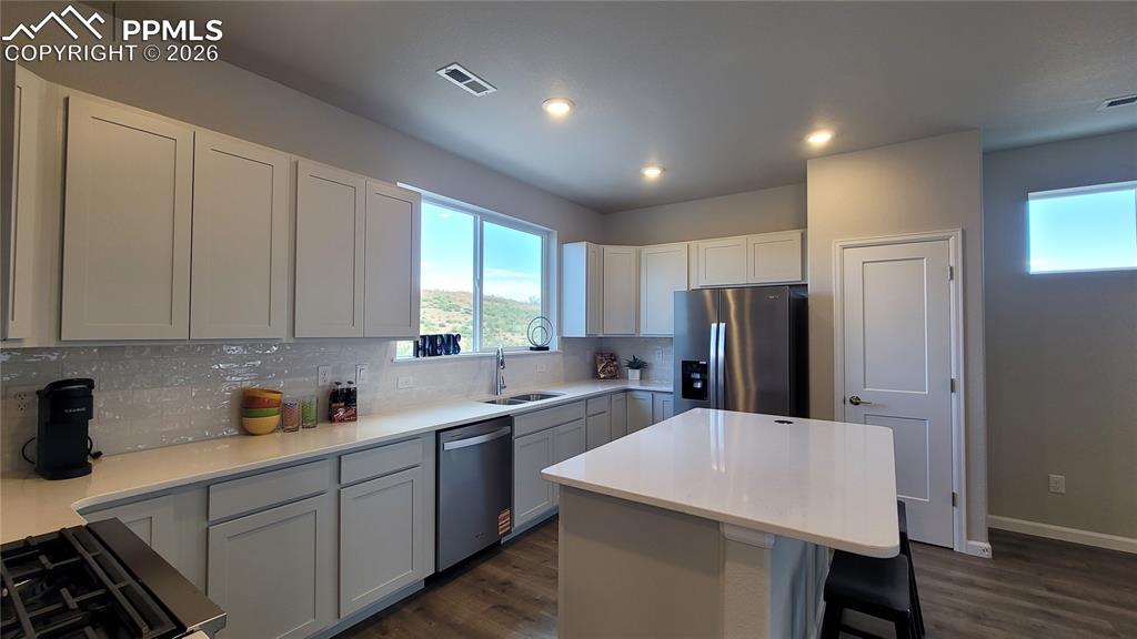 Image 14 of 28: Kitchen with Quartz countertop, pantry, island providing additional seating