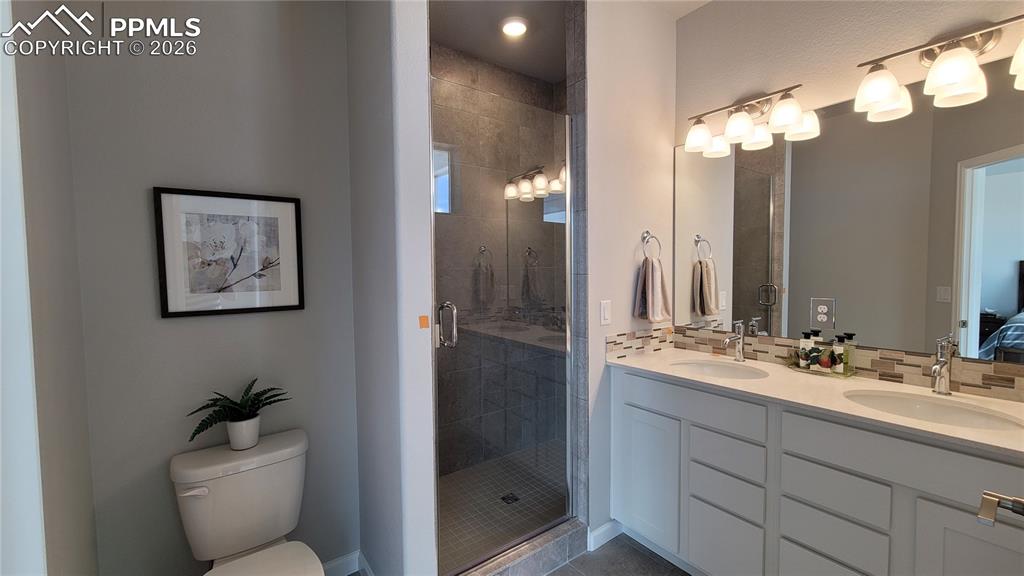 Image 20 of 28: Primary Bathroom, double vanity, quartz countertop and tile surrounds!