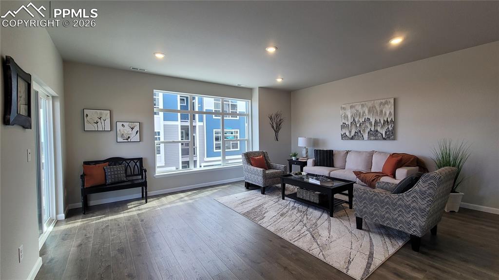 Image 8 of 28: Living room with LVP flooring, abundance of natural light, LED lighting, an
