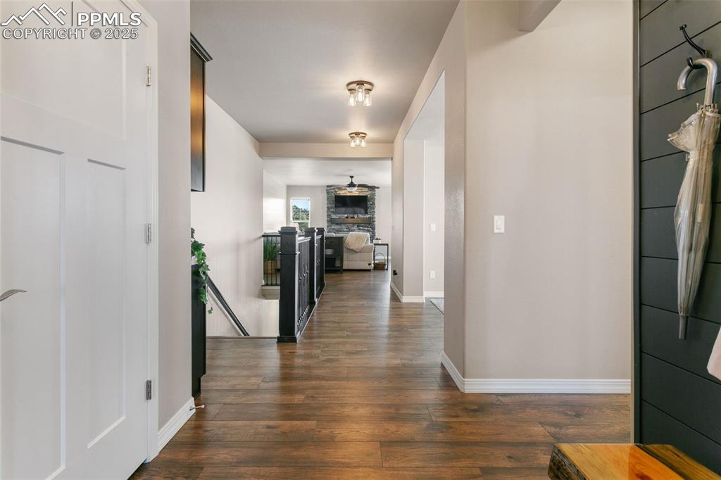Image 10 of 50: Hallway with dark wood finished floors and an upstairs landing