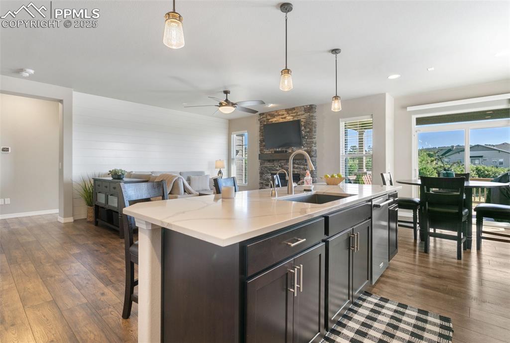 Image 22 of 50: Kitchen with a kitchen breakfast bar, decorative light fixtures, open floor