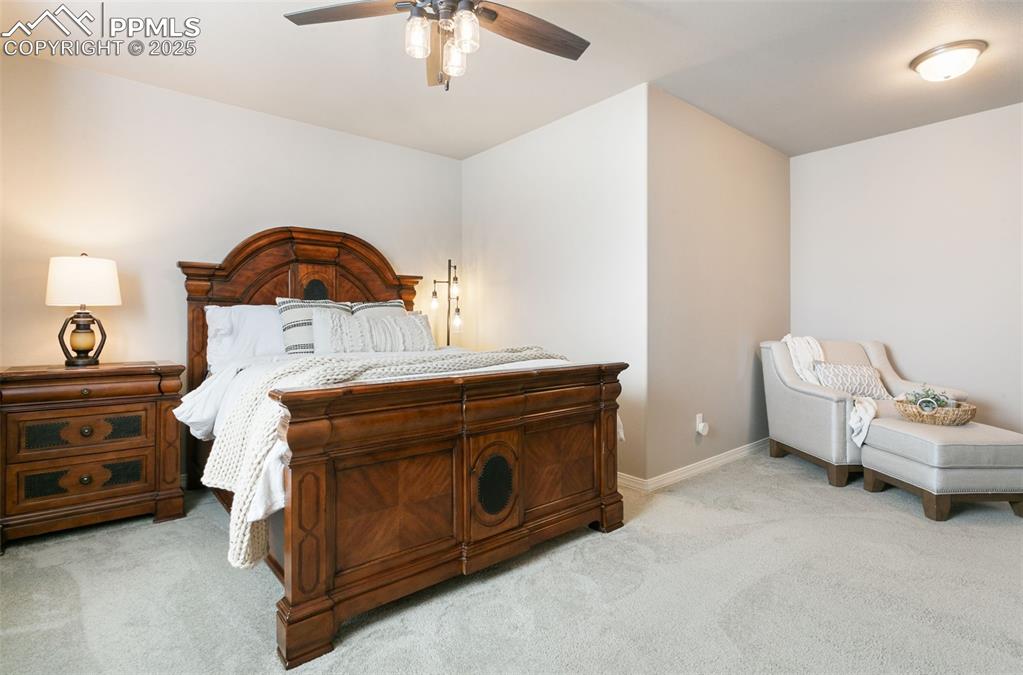 Image 28 of 50: Bedroom featuring light colored carpet and a ceiling fan