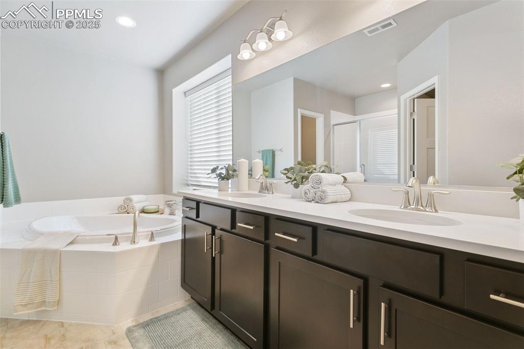 Image 30 of 50: Bathroom featuring a stall shower, recessed lighting, a bath, double vanity