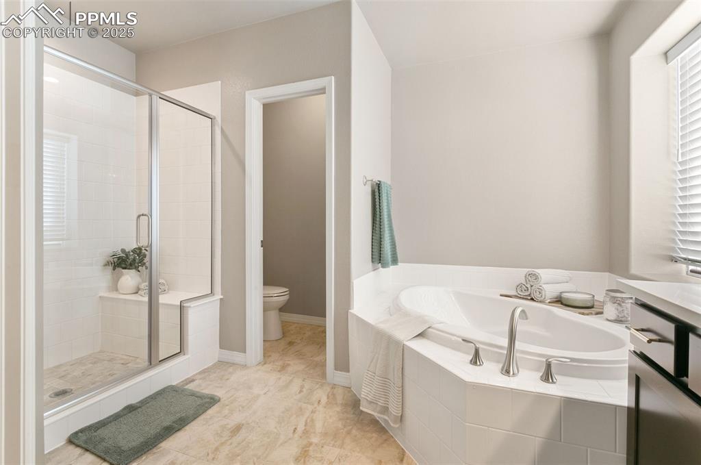 Image 31 of 50: Bathroom featuring a stall shower, a bath, and light tile patterned floors