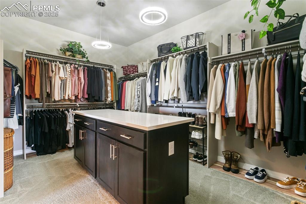 Image 34 of 50: Walk in closet featuring light colored carpet
