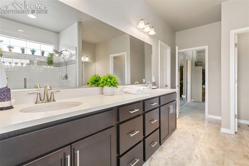 Image 36 of 50: Bathroom featuring double vanity and a stall shower