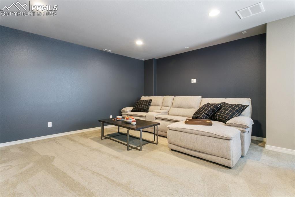 Image 41 of 50: Living area featuring light carpet and recessed lighting