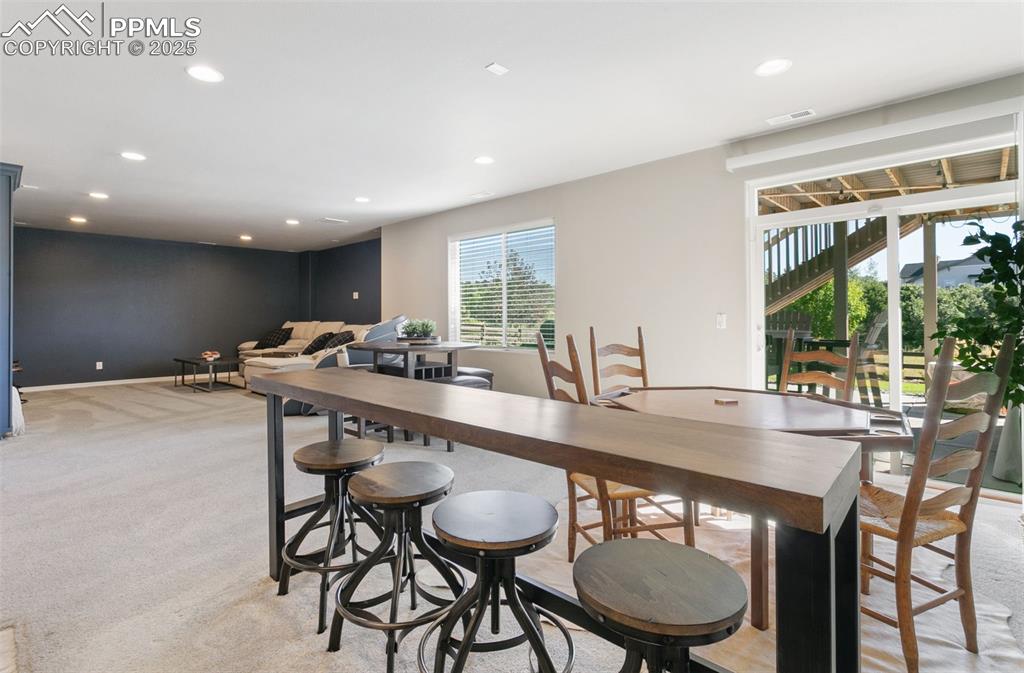 Image 44 of 50: Dining area featuring recessed lighting and light carpet