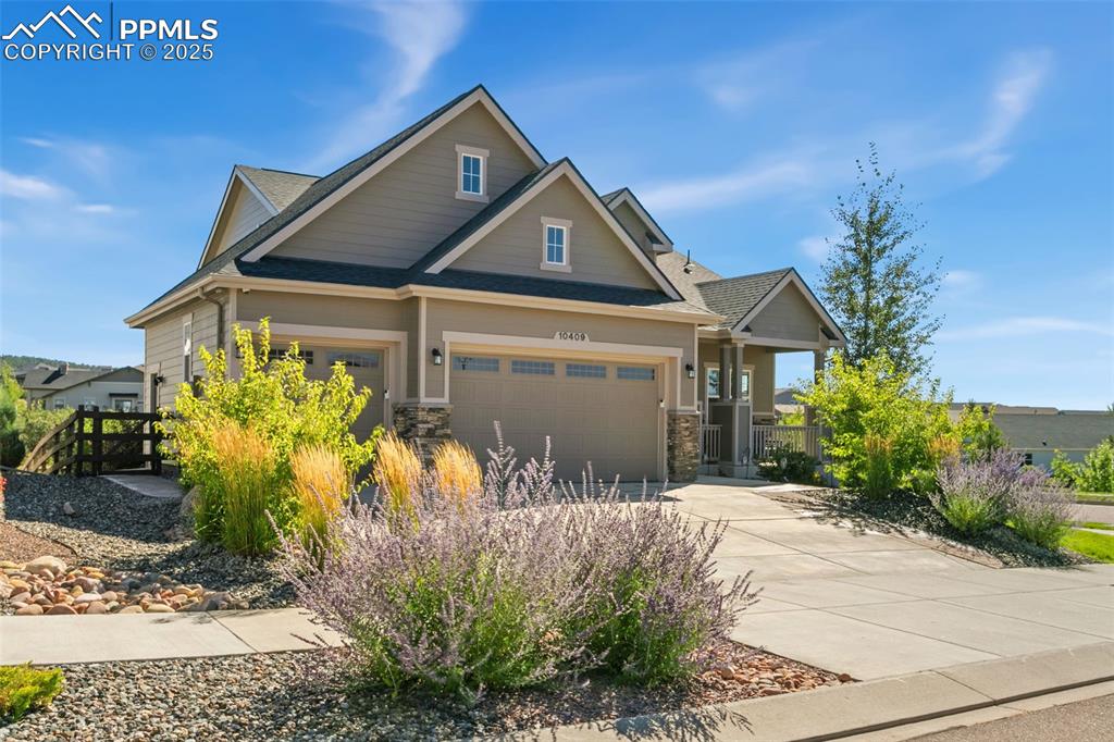 Image 8 of 50: Craftsman house featuring roof with shingles, driveway, a garage, and stone