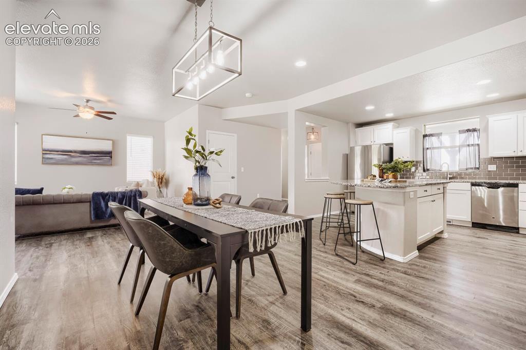 Image 10 of 35: Spacious open-concept living area featuring wood-finish flooring, a contemp