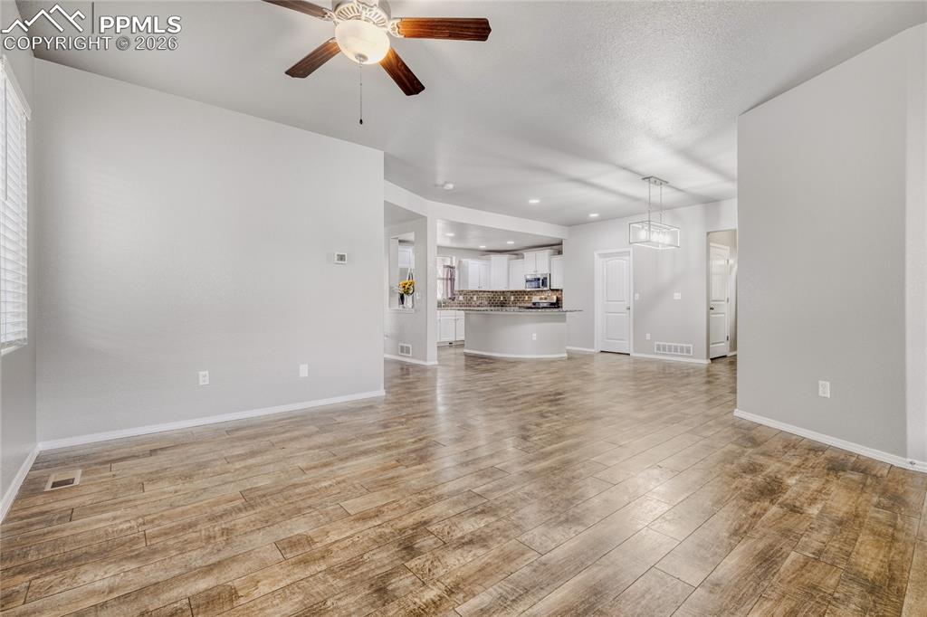 Image 14 of 34: Living room featuring a ceiling fan and LVP floors