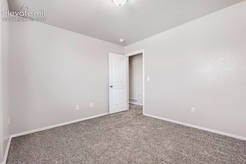 Image 16 of 35: Spacious room featuring neutral carpeting, light gray wall paint, white bas