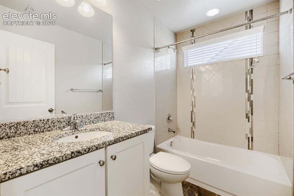 Image 17 of 35: Bathroom featuring a spacious vanity with a speckled countertop, a large fr