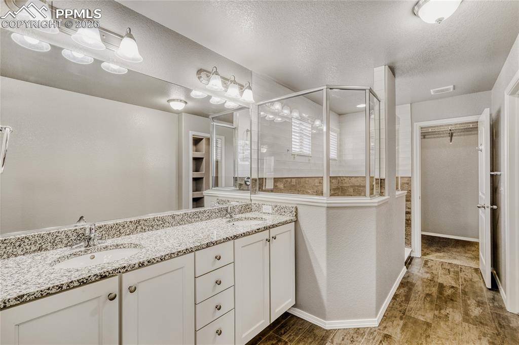 Image 23 of 34: Master bathroom featuring a spacious closet, double vanity, tile floors, wa