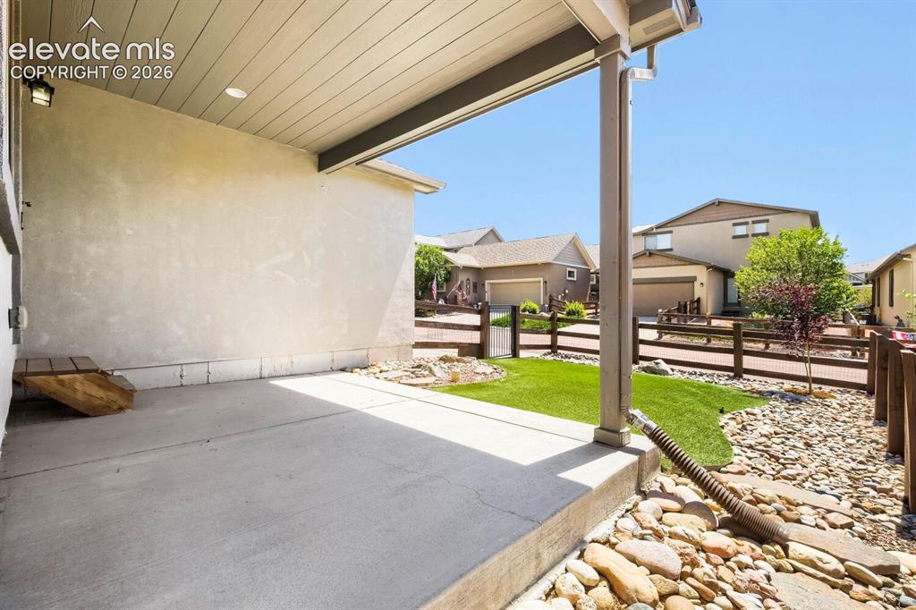 Image 25 of 35: Covered patio featuring a concrete surface and stucco exterior