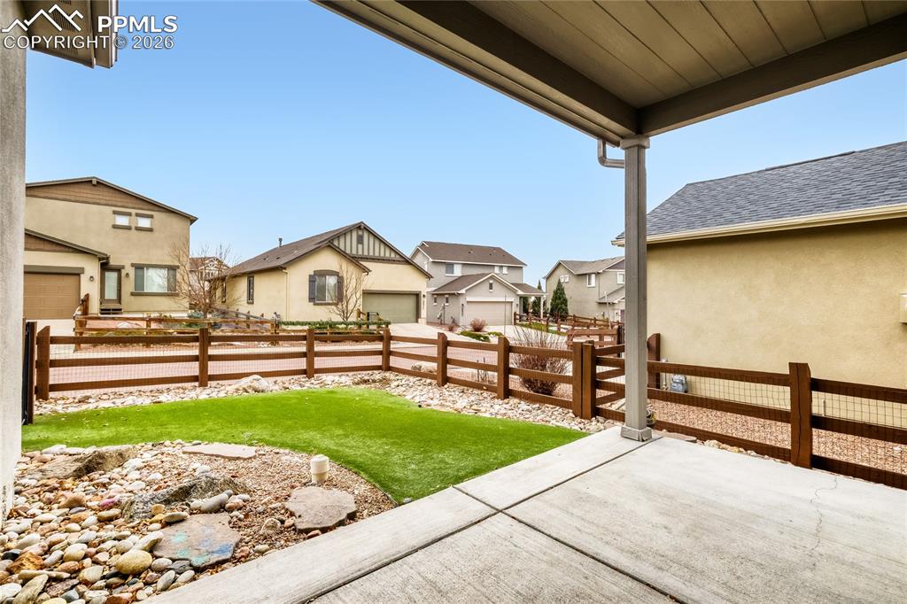 Image 26 of 34: Fenced backyard with a patio and a residential view
