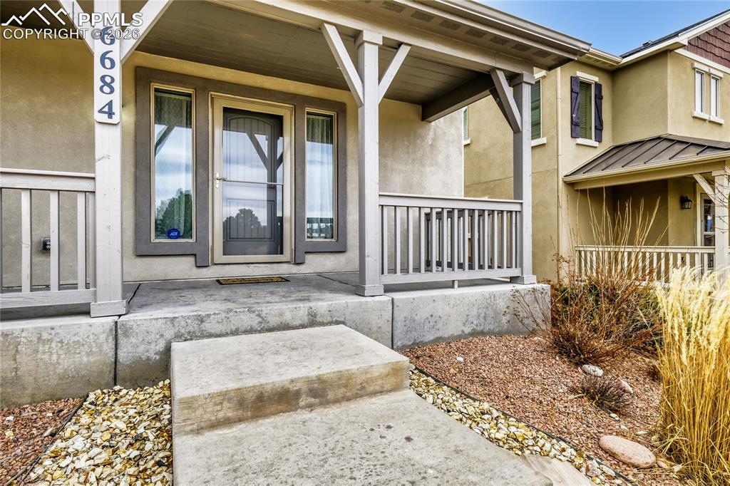 Image 3 of 34: Property entrance with stucco and covered porch