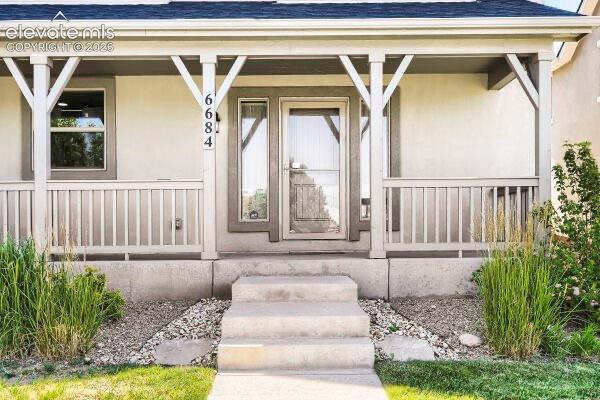Image 3 of 35: Inviting front porch featuring a multi-pane storm door, a white baluster ra