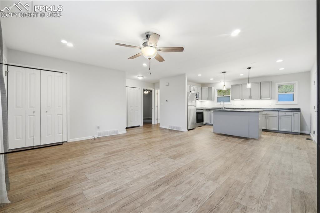 Image 10 of 24: Looking into the kitchen from the living room with remote control ceiling f