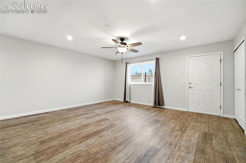 Image 11 of 24: HUGE living room with natural light and a remote controlled ceiling fan.