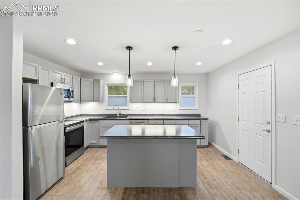 Image 7 of 24: This kitchen is gorgeous with lots of cabinet space and a functional island
