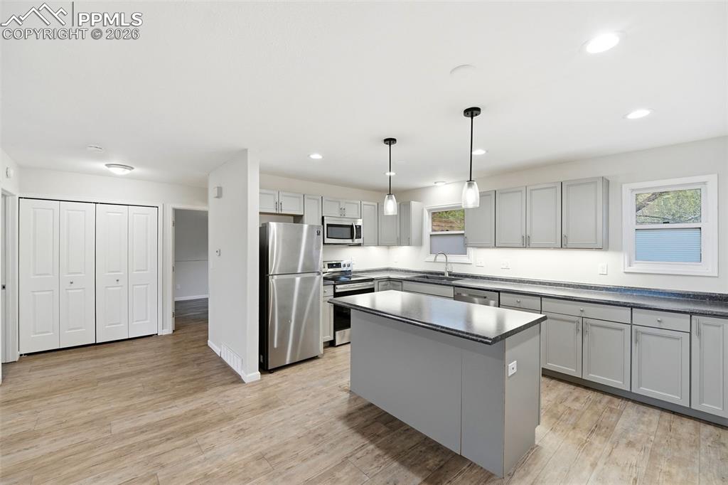 Image 8 of 24: Kitchen island and convenient laundry closet. 