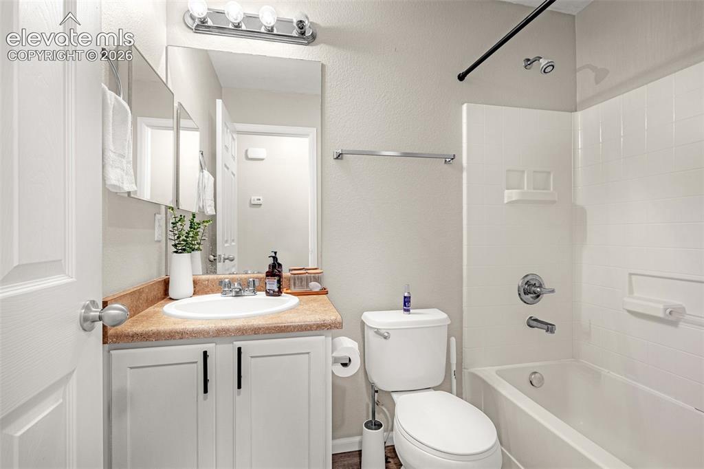 Image 14 of 37: Bathroom featuring a vanity with a surface-mount sink, chrome faucet, white
