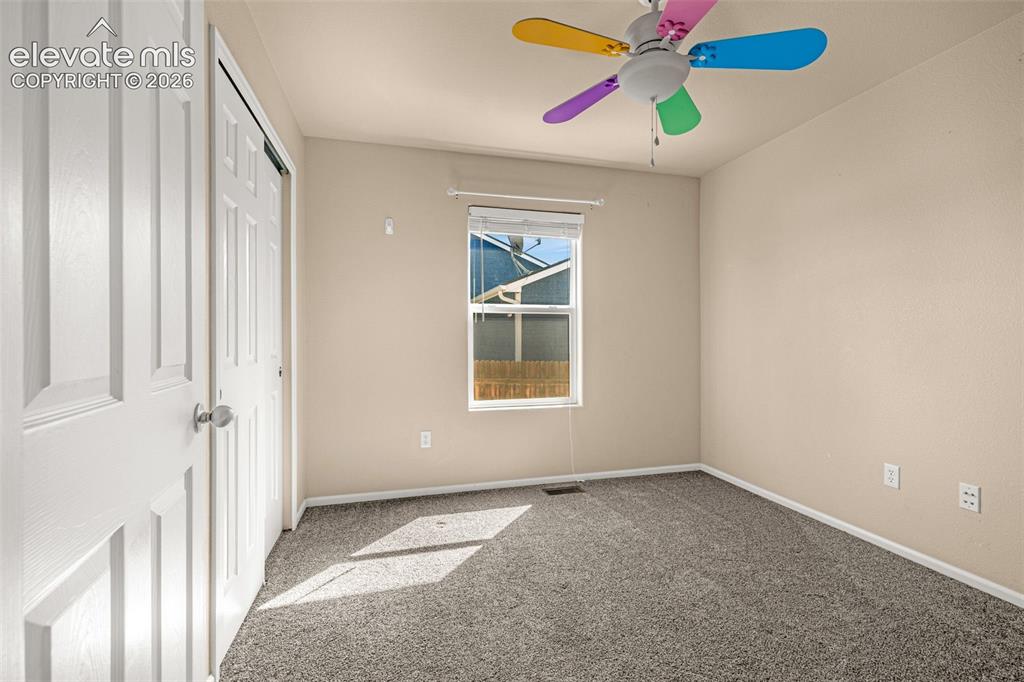 Image 15 of 37: Neutral wall paint, gray carpet, paneled closet door, window with blinds, a