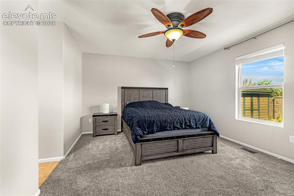 Image 17 of 37: Carpeted room with a ceiling fan light fixture and a window with blinds