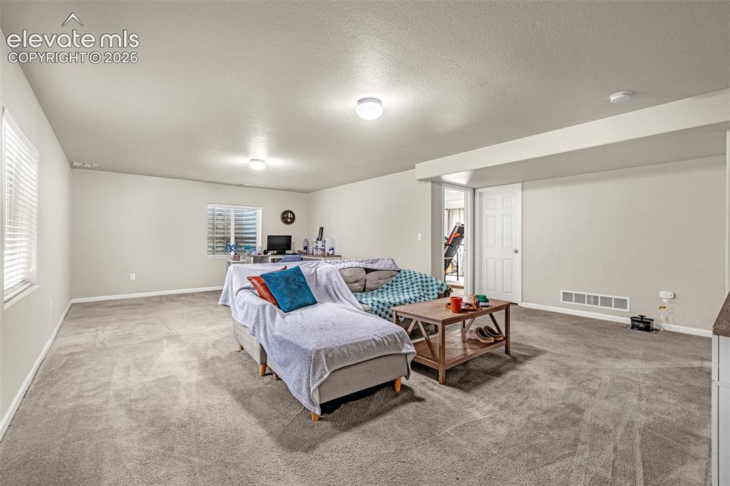 Image 21 of 37: Carpeted recreation room with recessed lighting and a window featuring hori