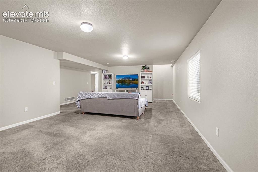 Image 23 of 37: Spacious interior with neutral wall colors, recessed lighting, and a window