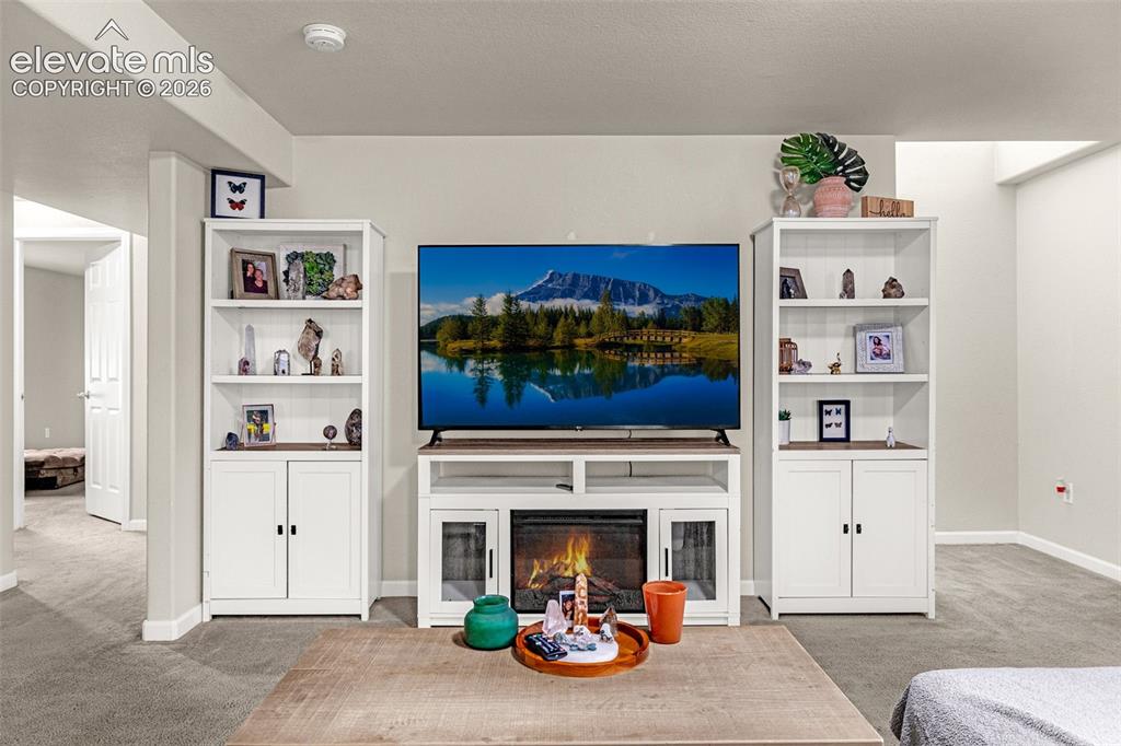 Image 24 of 37: Built-in media console with integrated electric fireplace and flanking stor