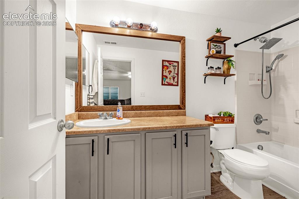 Image 27 of 37: Bathroom featuring a wood-framed mirror, vanity with a light-colored counte