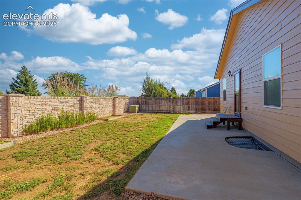 Image 30 of 37: Concrete patio with direct exterior access and a stone accent wall