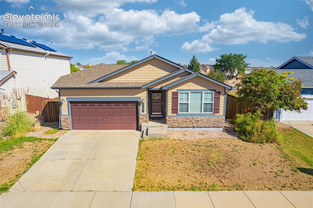 Image 37 of 37: Single-story residence featuring a two-car garage, stone veneer accents, an