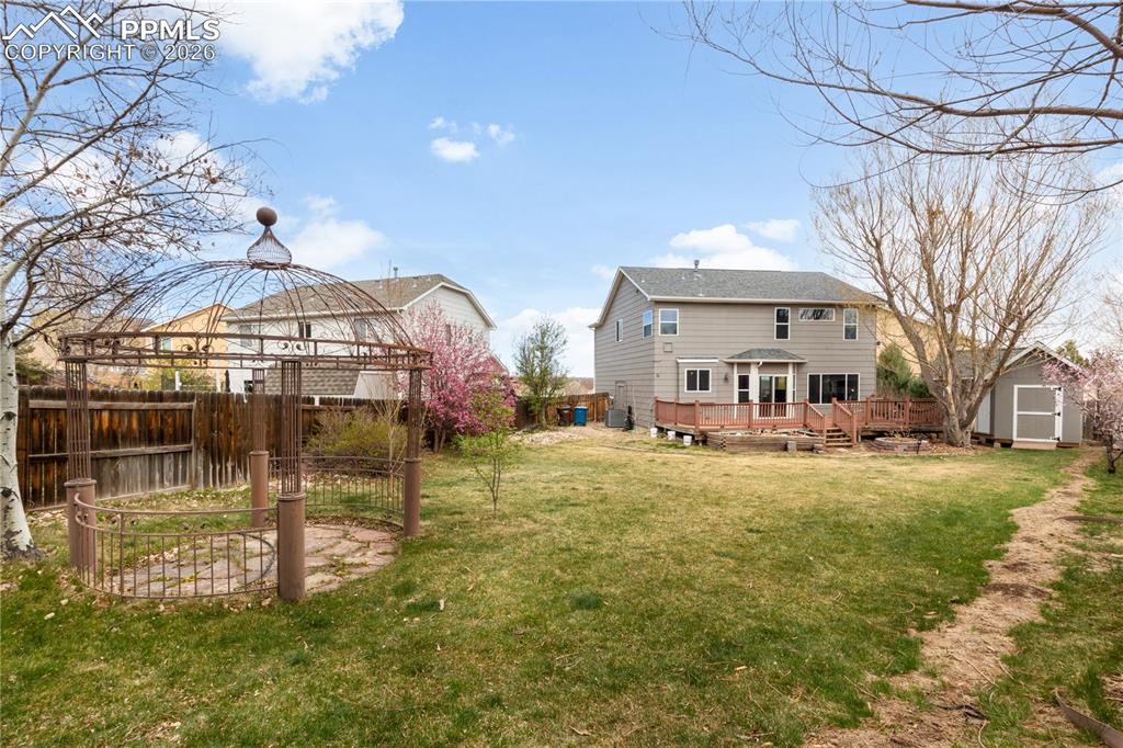 Image 34 of 39: Rear view of property featuring a shed and a wooden deck